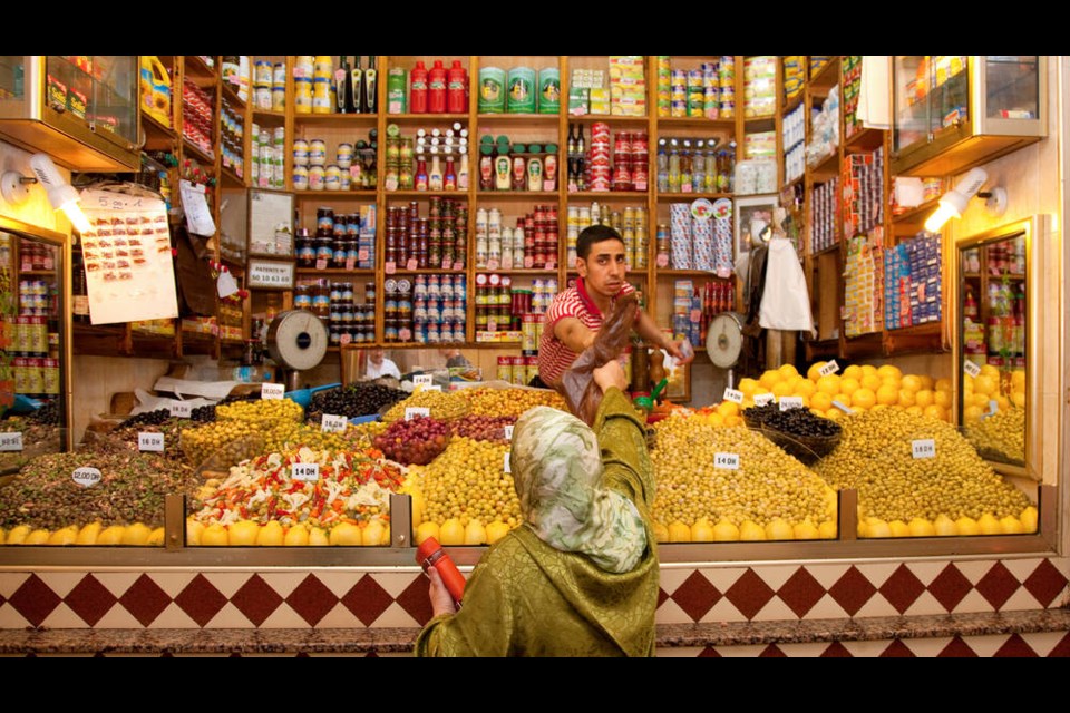 A shopkeeper and his customer in a market deep in Tangier’s old town. Tangier’s market boasts piles of fruits, veggies, and olives, countless varieties of bread, and non-perishables like clothing and electronics. DOMINIC ARIZONA BONUCCELLI 
