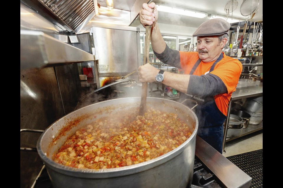 Mike Dillistone stirs a vat of jambalaya at the Rainbow Kitchen, which receives funding from the Times Colonist Christmas Fund. DARREN STONE, TIMES COLONIST 