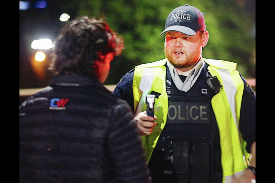 Below: Sidney-North Saanich RCMP Const. Chris Snider ­prepares to administer a breathalyzer test at a ­CounterAttack roadblock.  