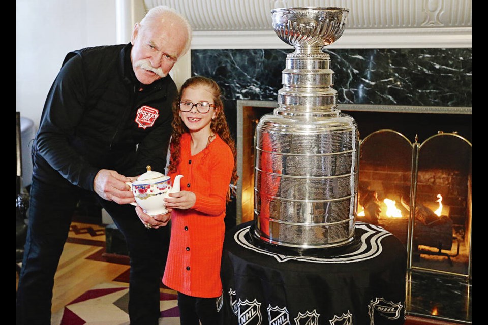 A win-win situation: Two cups in one day. Lucy McKenzie, who turns 8 next week, with former NHLer Lanny McDonald in front of the Stanley Cup in the Fairmont Empress’s tea room on Friday. The Fairmont Empress’s Cynthia Tremblay-Lorrain and keeper of the cup Jeff McWhinney with the Grey Cup in the lobby. PHOTOS BY ADRIAN LAM, TIMES COLONIST  