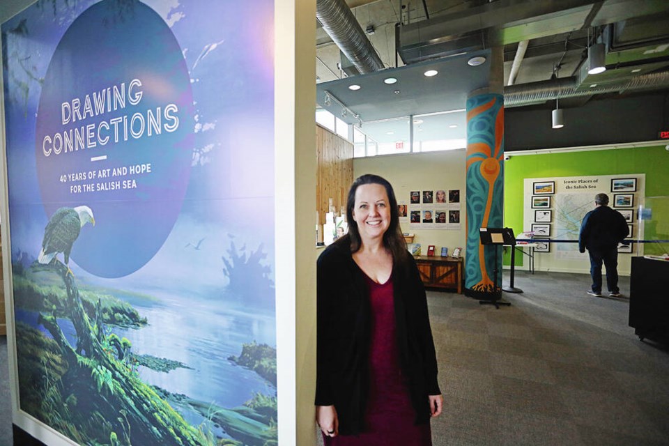Leah Thorpe, director of exhibits and engagement at the Shaw Centre for the Salish Sea, at the entrance to the new exhibit, Drawing Connections: 40 Years of Art and Hope for the Salish Sea. Art helps bring nature to the forefront, while bringing us face to face with what we risk losing, Thorpe says.  PHOTOS BY ADRIAN LAM, TIMES COLONIST 