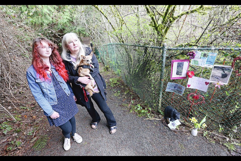 Andrea Miller with Binoo and her daughter Alaina Miller built a memorial for a black bear that was killed by conservation officers, orphaning three cubs last June. They were part of a push in View Royal to start a pilot program on bear-proof garbage containers. ADRIAN LAM, TIMES COLONIST 