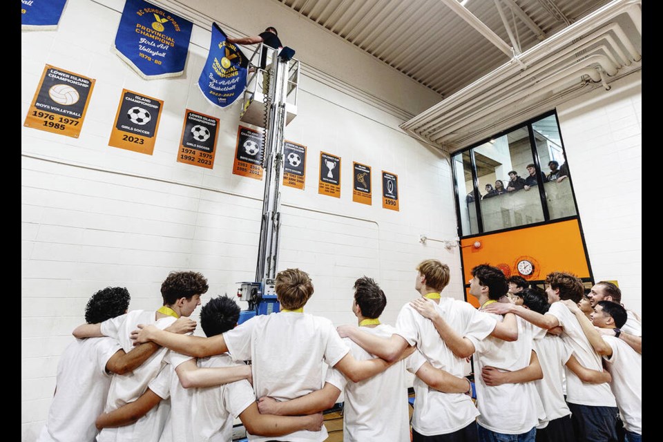 VICTORIA, B.C.: MARCH 11/2024-The BC boys AAAA basketball champion Spectrum Thunder team watch as head coach Tyler Verde installs the championship banner after a celebration ceremony in the Spectrum Community School gym in Victoria, B.C. March 11, 2024. (DARREN STONE, TIMES COLONIST). For City story by Cleve Dheensaw. 