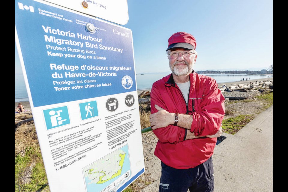 Jacques Sirois, chair of the Friends of Victoria Harbour Migratory Bird Sanctuary, with A federal sign on Willows Beach. DARREN STONE, TIMES COLONIST 