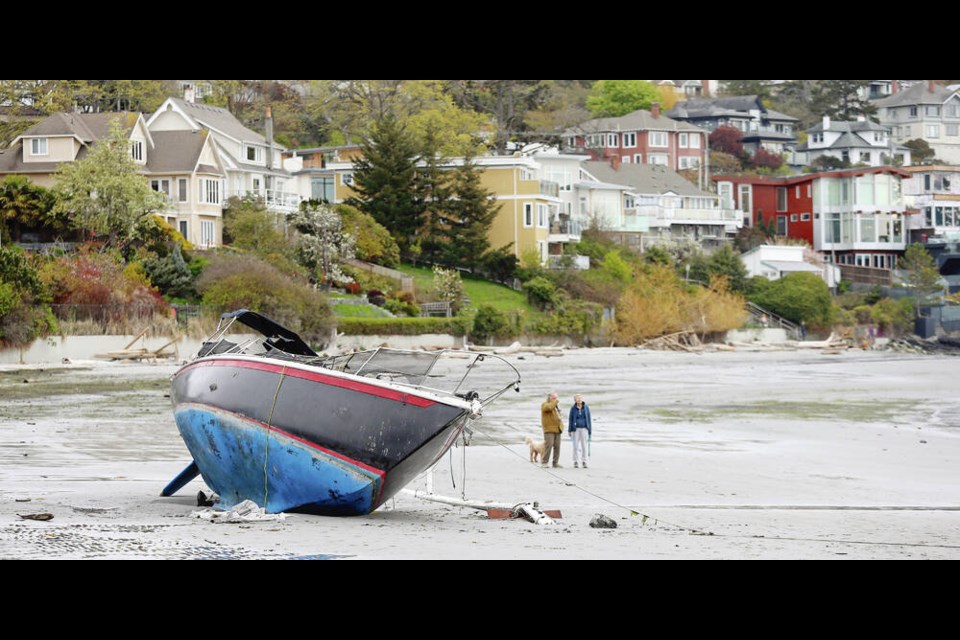 A sailboat on Gonzales Beach in Victoria on Thursday. The vessel was beached after a storm last month and is embedded in the sand. Locals say the owner continues to stay in the boat, which is being monitored by the coast guard. Story, A5 ADRIAN LAM, TIMES COLONIST 