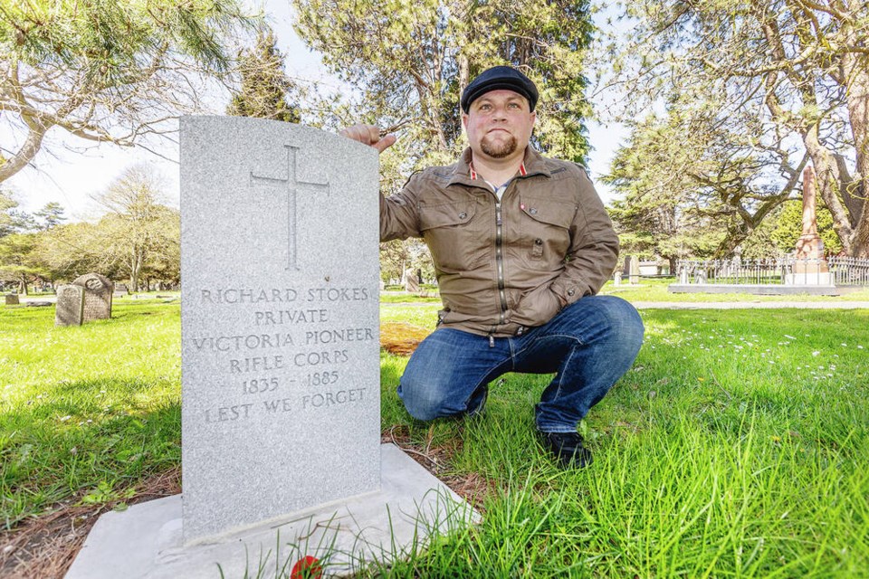 Kyle Scott with the headstone of Richard Stokes, a member of the 19th-century Victoria Pioneer Rifle Corps, at Ross Bay Cemetery. DARREN STONE, TIMES COLONIST 