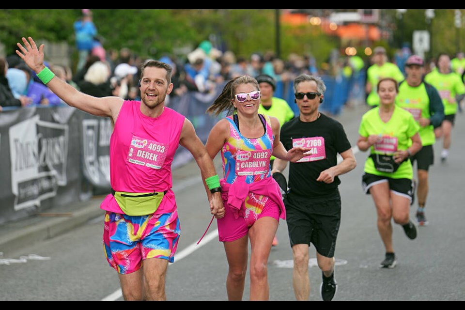 Derek and Carolyn Dykeman, clad in bright neon outfits from the Barbie movie, cross the finish line during the 35th running of the Times Colonist 10K in Victoria on Sunday, April 28, 2024. ADRIAN LAM, TIMES COLONIST 