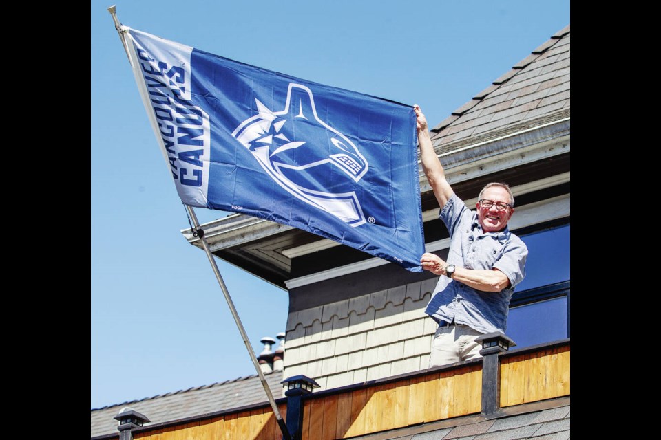 At Christie’s Carriage House, owner Brock Carbery flies the Vancouver Canucks flag from the roof of the Fort Street pub. DARREN STONE, TIMES COLONIST 