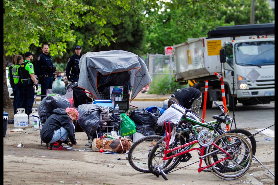 City of Victoria bylaw officers clear camps in the 900-block of Pandora Avenue on Thursday. DARREN STONE, TIMES COLONIST 