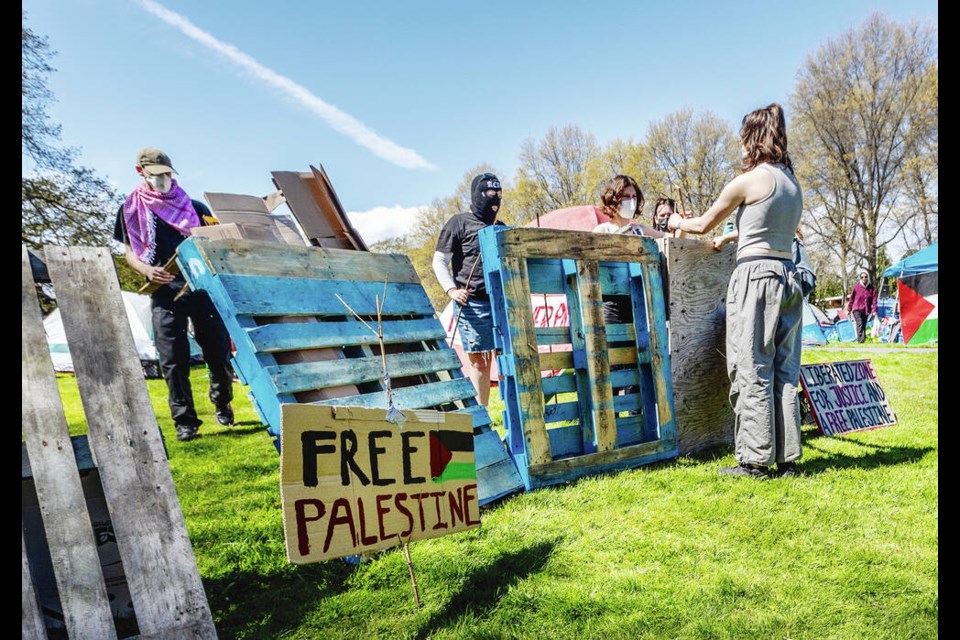 Protesters make a wall with wooden pallets at an encampment near the McPherson Library at the University of Victoria on Wednesday. DARREN STONE, TIMES COLONIST 
