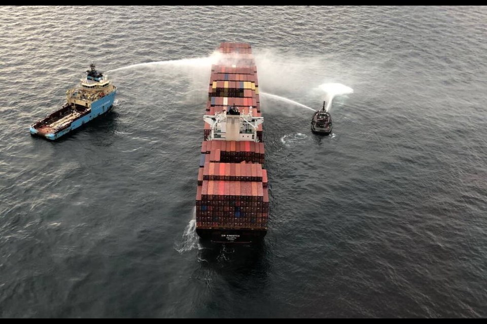 Water is sprayed onto the hull of the container ship Zim Kingston, which is anchored off Victoria. Hazardous chemicals in some of the containers caught fire. Because of the nature of the chemicals, water could not be sprayed directly on the fire.    CANADIAN COAST GUARD.  Oct. 24, 2021 