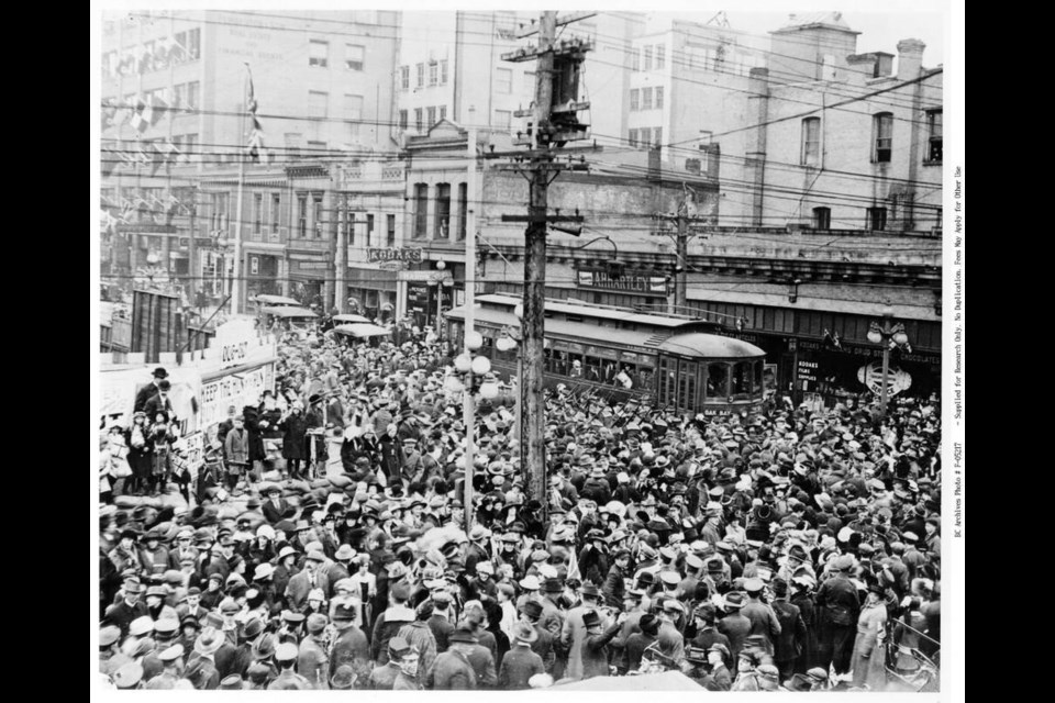 A crowd forms at the corner of Fort and Government streets on Nov. 7, 1918, following rumours of ­armistice. In October 1918, with upwards of 100 cases of  influenza already reported in Victoria, Victoria’s ­medical health officer, Dr. Arthur G. Price, closed schools, churches, libraries, theatres, colleges and dance halls for 33 days, and banned community gatherings.  IMAGE F-05217 COURTESY OF BC ARCHIVES 