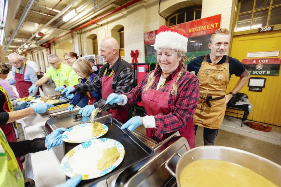 Carolyne Taylor serves up turkey dinner during the Mustard Seed’s Christmas celebration, Saturday. 
DARREN STONE, TIMES COLONIST  