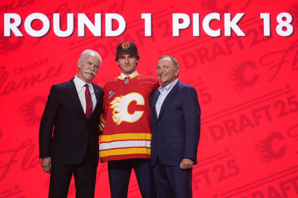 Cole Reschny stands with Lanny McDonald, left, and NHL commissioner Gary Bettman after being drafted by the Calgary Flames. DAMIAN DOVARGANES, AP