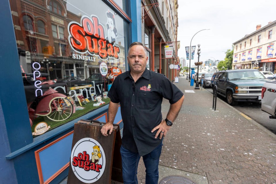 Oh Sugar owner Keith Johnson in front of his candy store on Johnson Street. “We definitely see that it doesn’t necessarily make financial sense to keep operating in the downtown core with just so much [negative] activity happening.” DARREN STONE, TIMES COLONIST 