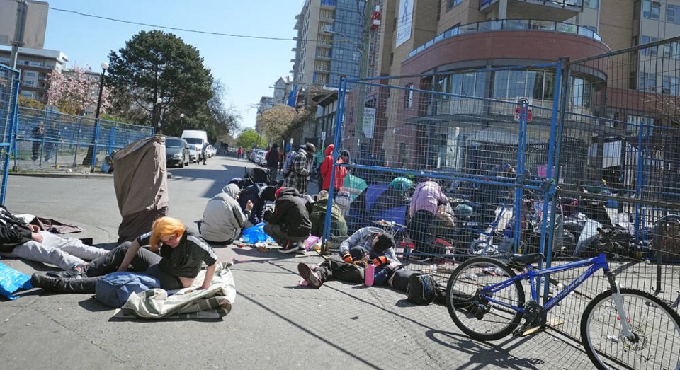 People in front of Our Place Society on Pandora Avenue in April. The financial and social costs of social disorder to the city centre are staggering, Gene Miller writes. ADRIAN LAM, TIMES COLONIST