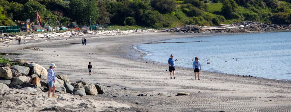 Beachgoers walk at Willows Beach in early June. DARREN STONE, TIMES COLONIST
