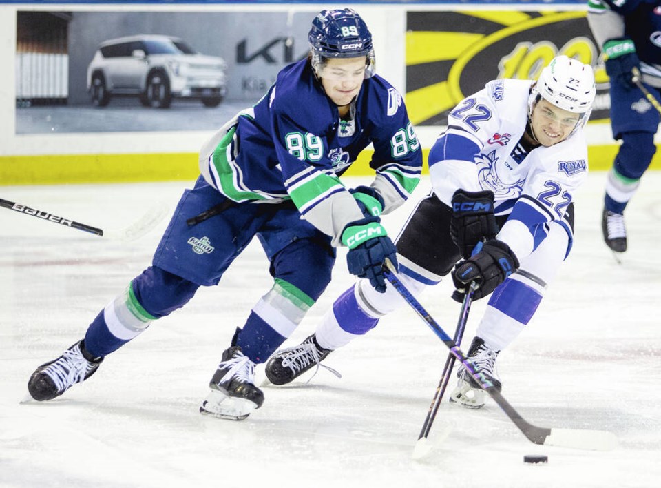 Royals forward Teydon Trembecky, right, grabs the puck from Seattle Thunderbirds forward Antonio Martorana. Trembecky was eligible to return to Victoria next season but has decided to leave to play in the NCAA. DARREN STONE, TIMES COLONIST