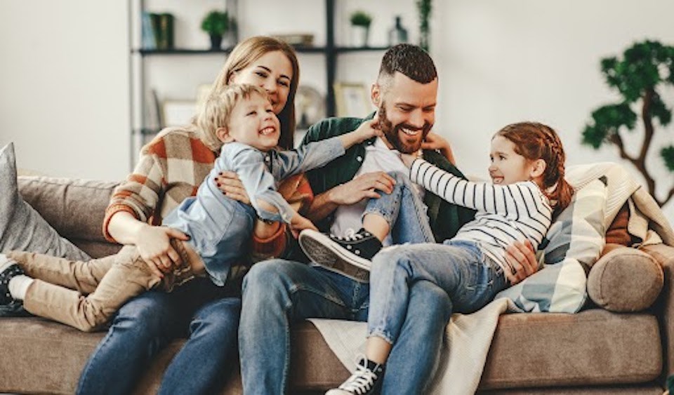 happy-family-mother-father-and-kids-at-home-on-couch