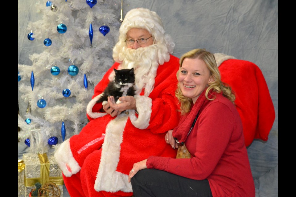 "Santa" and subject pose on pet picture day at Virden Animal Hospital with organizer Dr. Carla Loewen. 