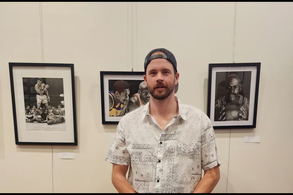 Artist Cody McPhee, a teacher at Virden Collegiate Institute, his art behind him revealing one of his other passions – sports.