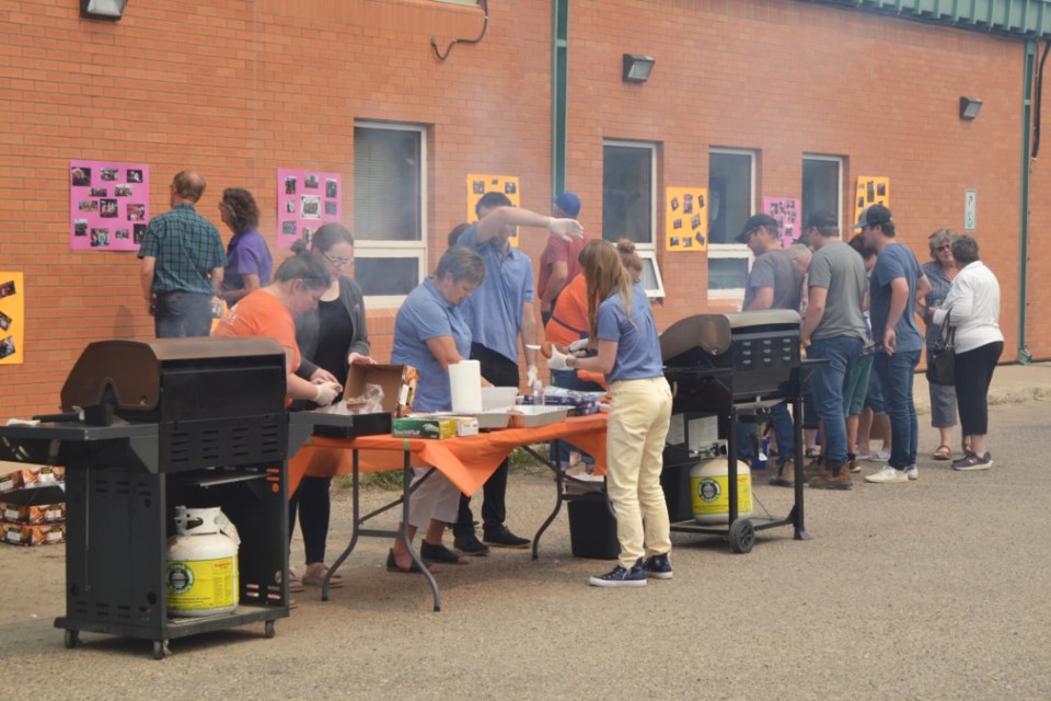 BBQ For Ukrainian Refugees - Sunrise Credit Union Virden Branch staff serve up lunch outdoors in their parking lot over the noon hour on July 14. Funds raised from the sale of hot dogs, burgers, chips and drinks will go to Virden 4 Ukraine, a local committee helping to integrate refugees from the war-torn country into the Virden community.