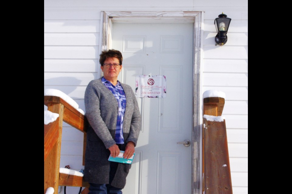 Denise at the entrance of her flower shop in Deleau.