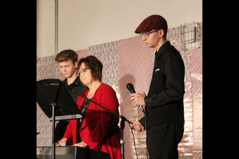 Elkhorn School Christmas Trio of (l-r) Joshua Baer, teacher Mrs. Sandra Unger and Lukas Baer, who performed a Christmas classic, "Adore" to a silent audience.gym.