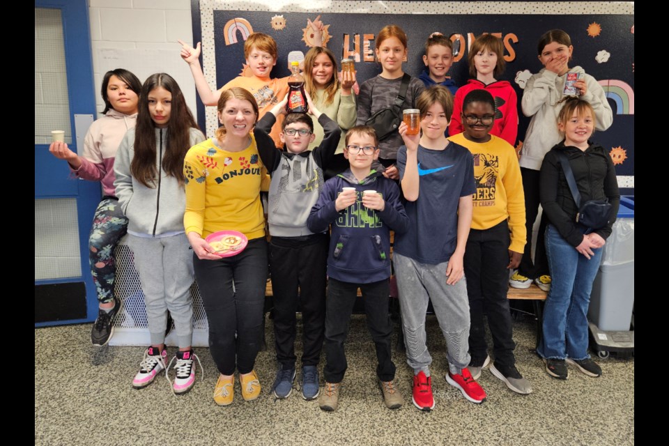 Mrs. BW (front, gold tshirt) and her Gr. 5 class (minus a few students this day) have learned about making maple syrup. Students are holding maple syrup samples - one from Quebec sugar maples, other smaples are condensed from Manitoba maples. 