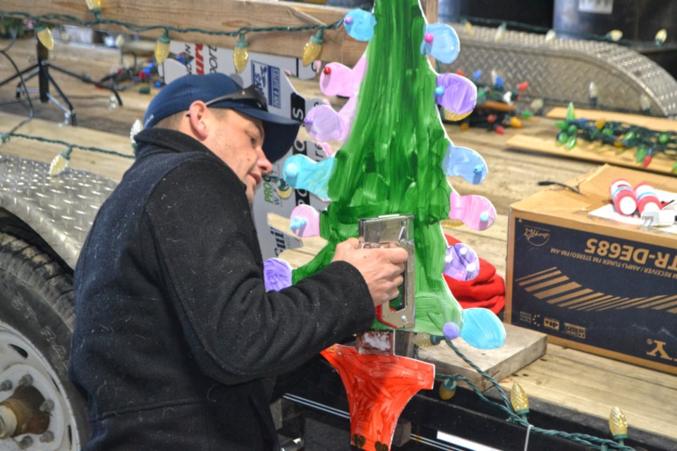 Chris Scott attaches a "Who-Ville" Christmas tree to the Very Virden Christmas float. PHOTO/LINDSAY WHITE
