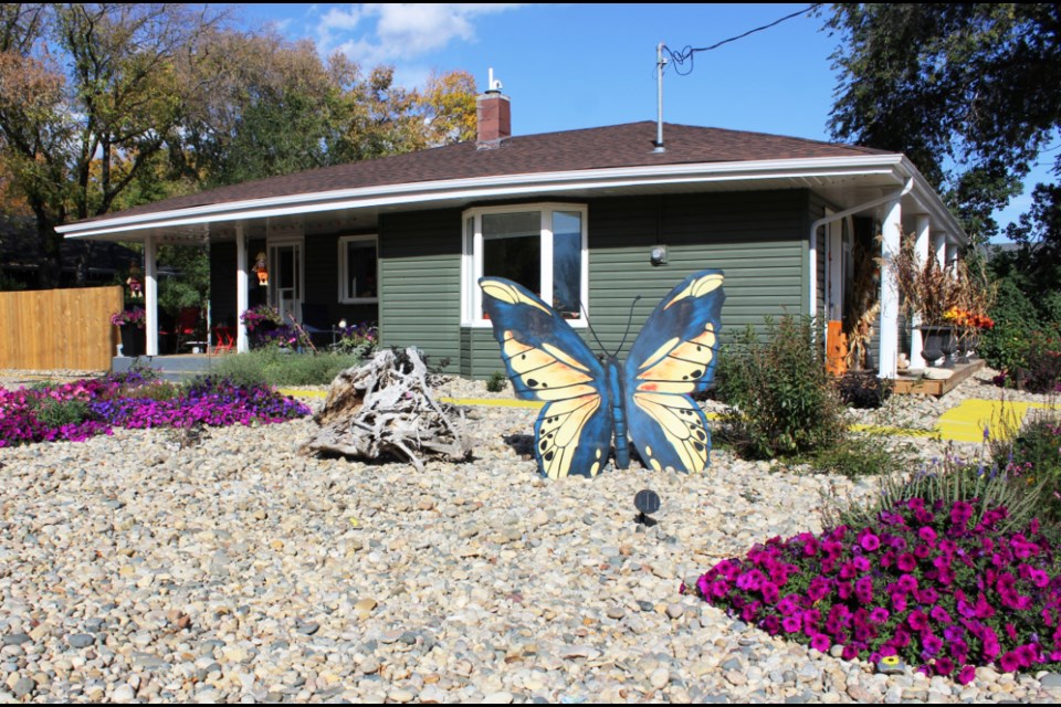 Landscaping with stone, a huge butterfly and water-weathered tree roots draw the eye of passersby to Eileen Calcut's corner lot in Virden.