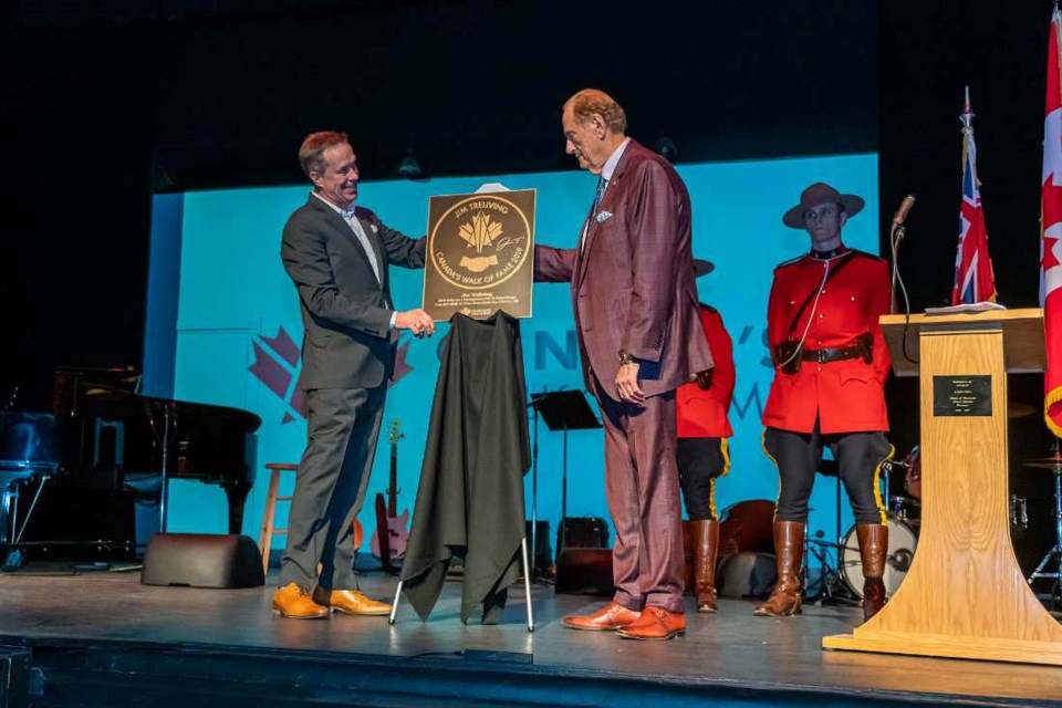 On the Virden Aud Theatre stage, Canada's Walk of Fame President and CEO, Jeffrey Latimer presents 2019 Inductee Jim Treliving with his Hometown Star, presented by Cineplex.