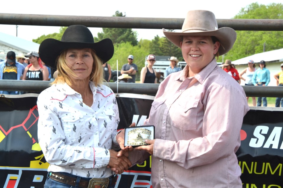 Janet Rankin, co-organizer of the Don't Give a Buck Barrel Racing Jackpot presents Dawn Vandersteen of Austin with a buckle and $100 added prize money for winning the Breeder's Challenge. Her barrel horse, JR Royal Cash, was bred by Jacqueline Rookes of Elkhorn. This horse won her the 1D Select, 1D Open and 1D Derby categories, with an average time of 16.7255. Meanwhile, she took top spot in the 2D Open on her horse Little Miss Chrissy with an average time of 17.2605. 
