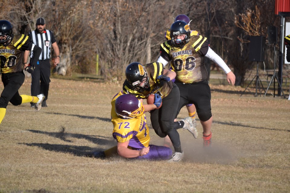 Moosomin Generals #11 Wyatt Fisk fights off a tackle from Golden Bears #72 Christian Lansing during the second half of the game.