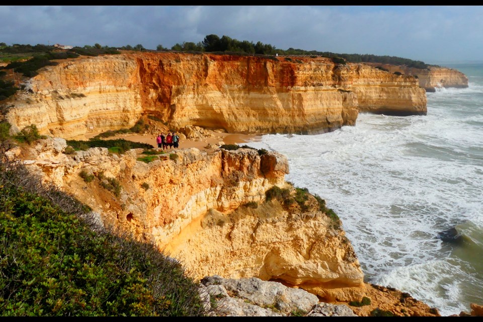The Miniota travellers stayed at the small fishing village of Benagil. In this photo they are dwarfed by the vast golden cliffs on Benagil Beach on Portugal’s Algarve southern coast. 
