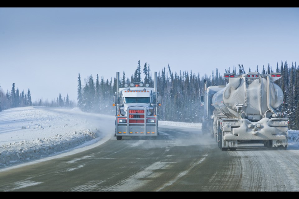 Two tanker trucks meet on a remote  winter road