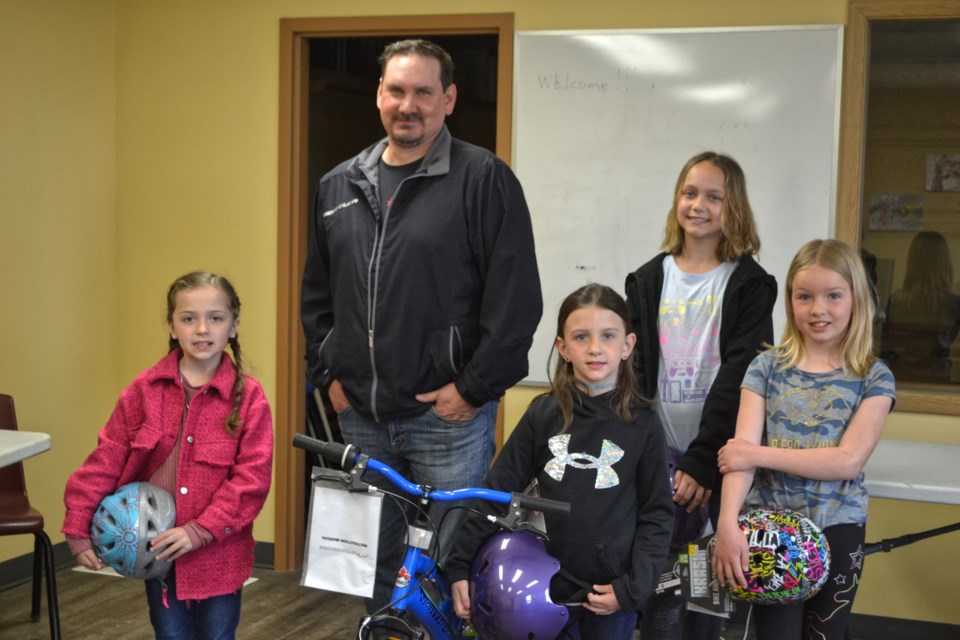 Mark Johnston, Supervisor of Operations for Fort La Bosse School Division, presented the winners of this year's bus ridership poster colouring contest with their prizes at the division’s operations building on May 18. Ava Hadley, left, a Grade 2 student at Mary Montgomery School, received a new bicycle and helmet. Also in the photo are Charlee Delaurier (Grade 1, Goulter School), Taylor Goulet (Grade 6, Oak Lake Community School) and Zoe Johnson (Grade 3, Elkhorn School) who each received helmets. Not pictured are helmet winners Carolyn Waldner (Kindergarten) and Dahlia Waldner (Grade 5), both of Plainview Colony; and Novalee Hack (Grade 4, Reston School) who received a new bicycle and helmet.   