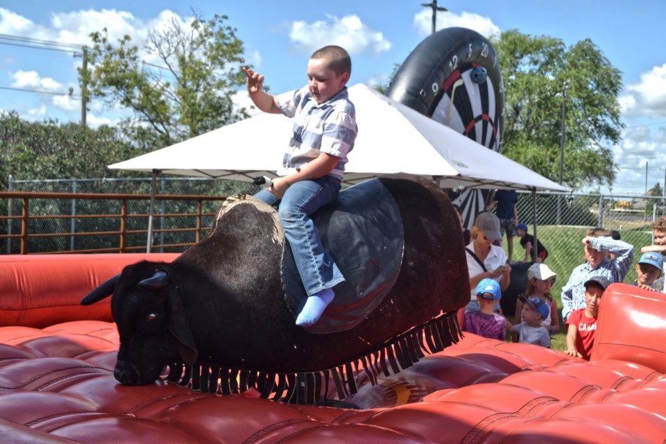 Youngsters attempt to stay on the mechanical bull for the full 8 seconds.
