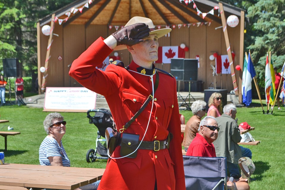RCMP Cst. Eric Sigurdson salutes as the Canadian Flag is raised high above Victoria Park during the Canada Day Opening Ceremonies on July 1.