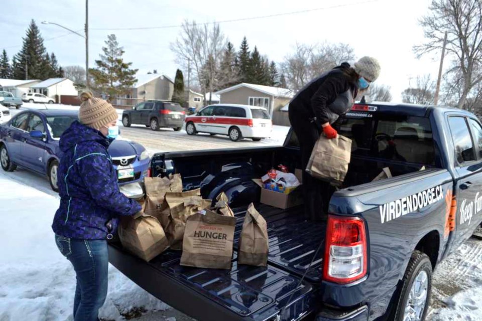 Shelby Swanson (l), Accounting Clerk at Virden Dodge, and Sales Consultant Kirsten Davidson unload non-perishable food donations at the Virden Baptist Church last Thursday, Nov. 25, marking the end of the Dodge "Keep Families Fed" food drive. Throughout November, "Good Buy to Hunger" bags were available for purchase at the Valleyview Consumers Co-op food store in Virden as well as the Twin Valley Co-op grocery store in Elkhorn. In total, 265 bags of food and over $2,400 in donations were collected and turned over to the Virden & Area Food Cupboard.