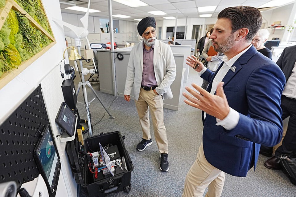 Harjit S. Sajjan, left, federal minister responsible for the Pacific Economic Development Agency of Canada, talks with Barnacle Systems CEO Brandon Wright on June 25. Sajjan announced funding to support ocean and marine technology projects. | Adrian Lam, Times Colonist 

