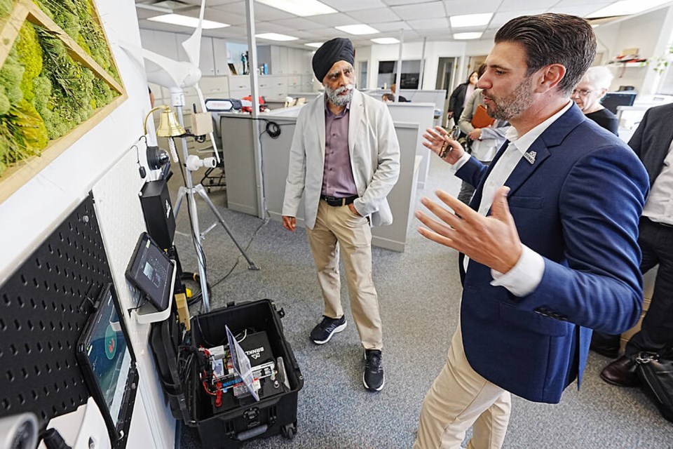Harjit S. Sajjan, left, federal minister responsible for the Pacific Economic Development Agency of Canada, talks with Barnacle Systems CEO Brandon Wright on June 25. Sajjan announced funding to support ocean and marine technology projects. | Adrian Lam, Times Colonist 

